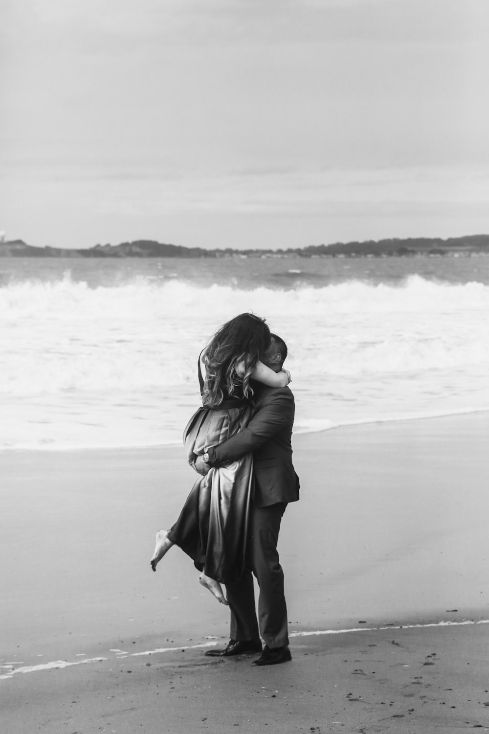 a man and a woman hug on the beach