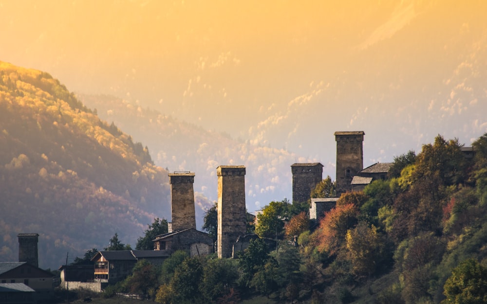 a row of towers on a hillside with a mountain in the background