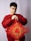 a man in a red sweater holding a red and gold decoration
