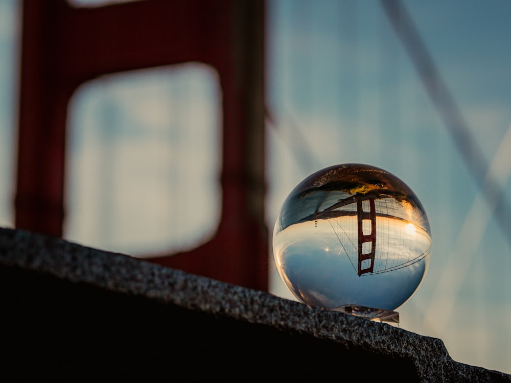 a glass ball sitting on top of a stone wall