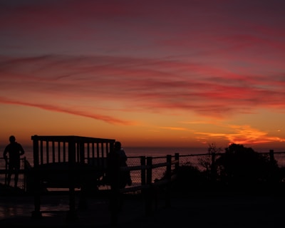 Sunset view from Mont Passot with silhouettes of travelers admiring the sky.