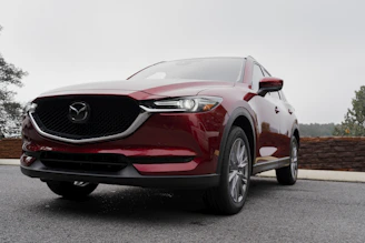 a red mazda cx - 5 parked in a parking lot