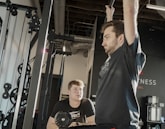 a man holding a barbell in a gym
