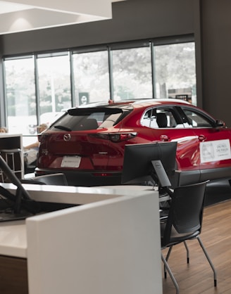a red car is parked in a showroom