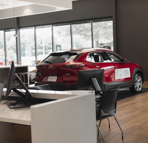 a red car is parked in a showroom