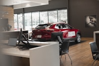 a red car is parked in a showroom