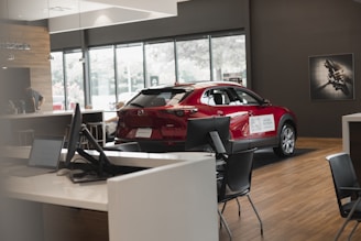 a red car is parked in a showroom
