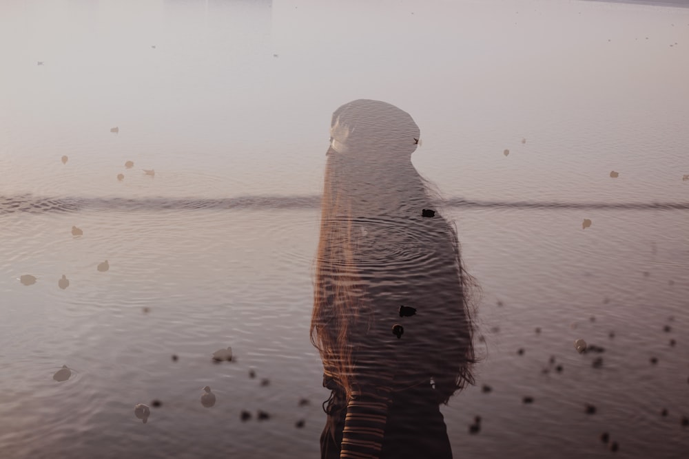 a woman is standing in the water with her head in the water