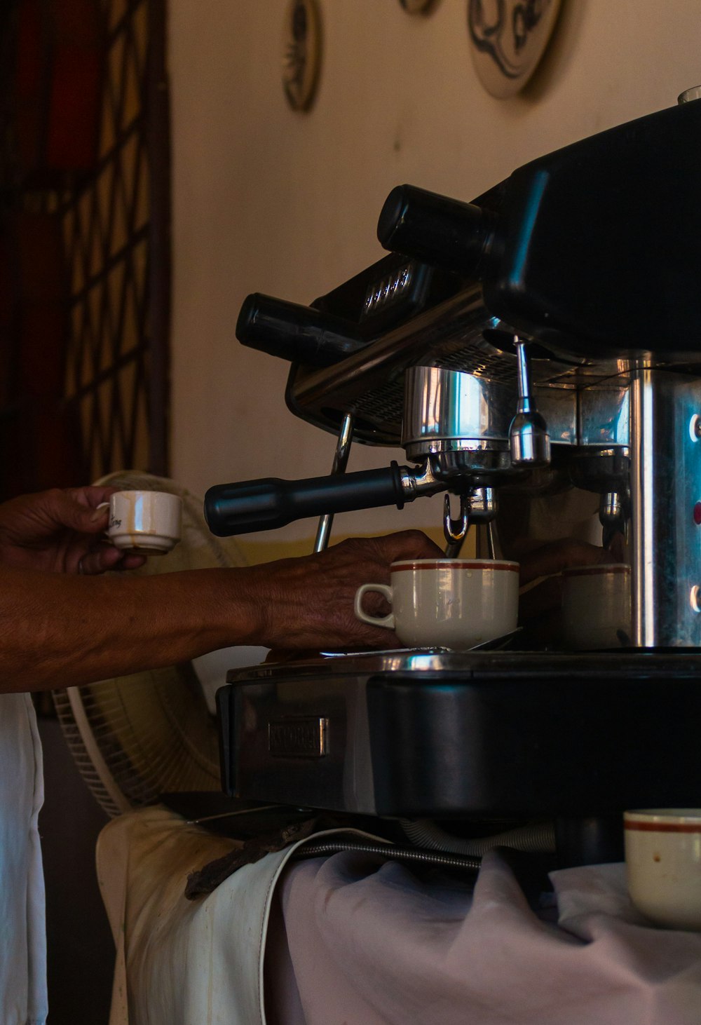 a person is using a coffee machine to make a cup of coffee