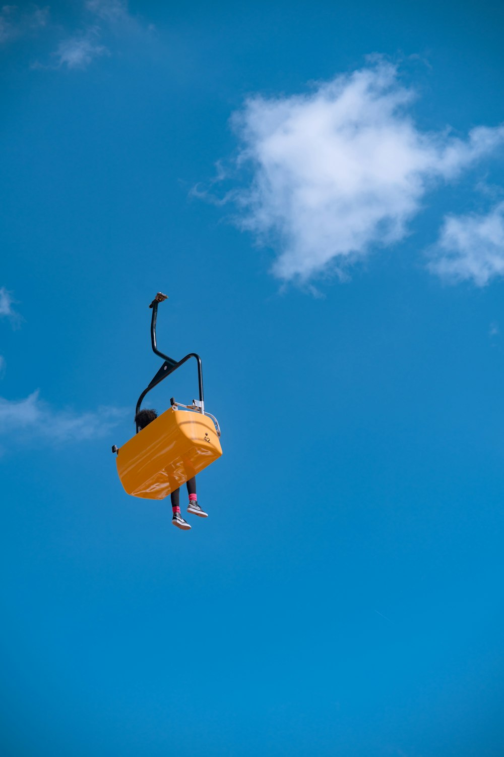 uma pessoa em uma cadeira amarela no ar