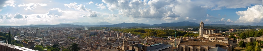 a panoramic view of a city with mountains in the background