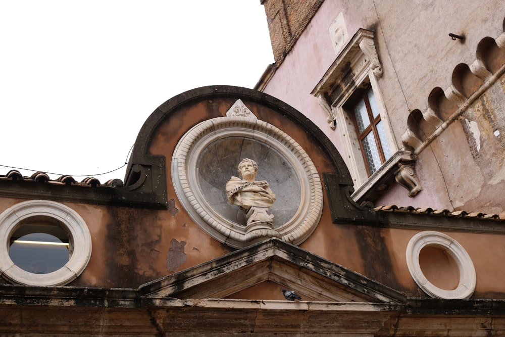 an old building with a statue on the front of it