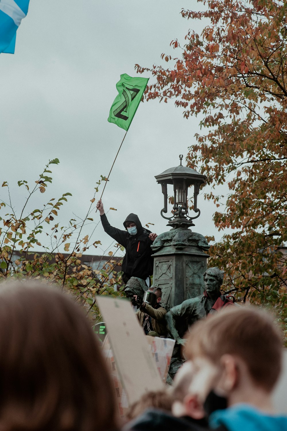 a man holding a flag on top of a statue