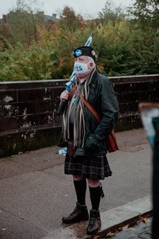 a man in a kilt and a cat mask