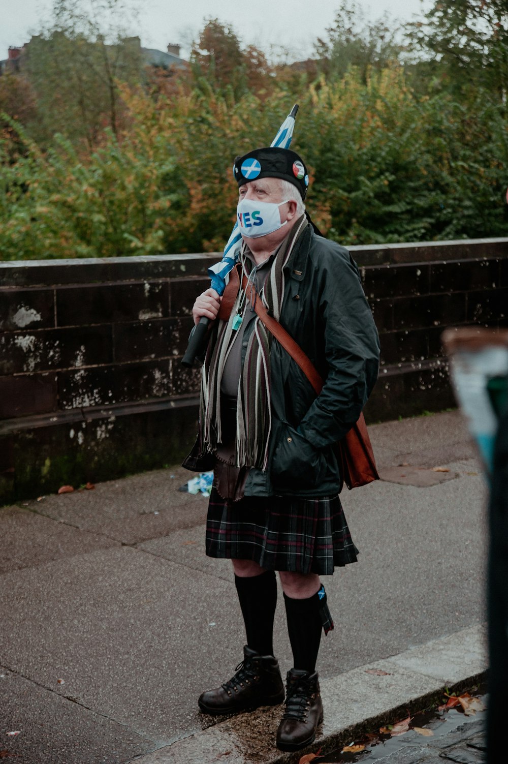 a man in a kilt and a cat mask