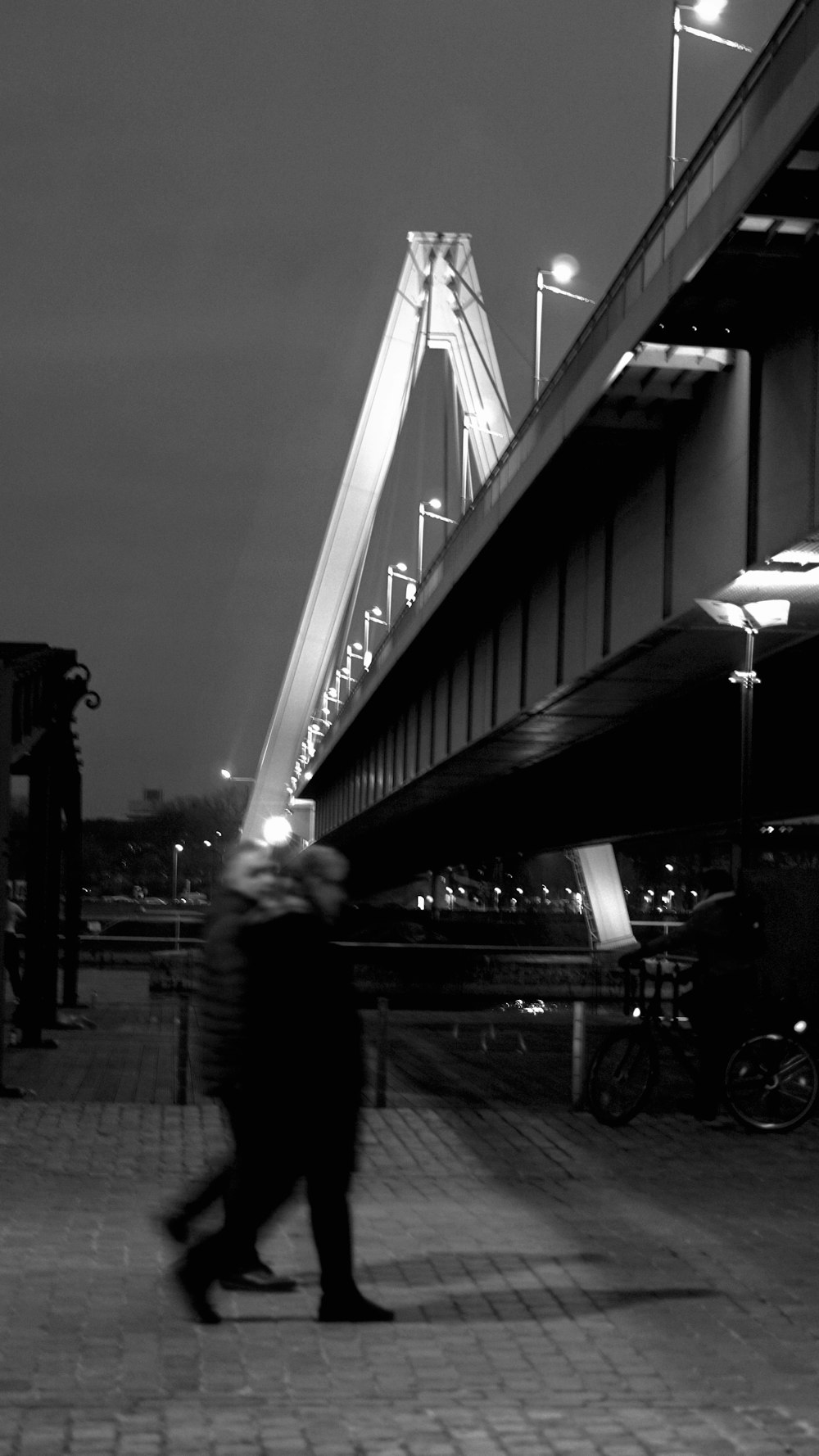 a black and white photo of a bridge at night