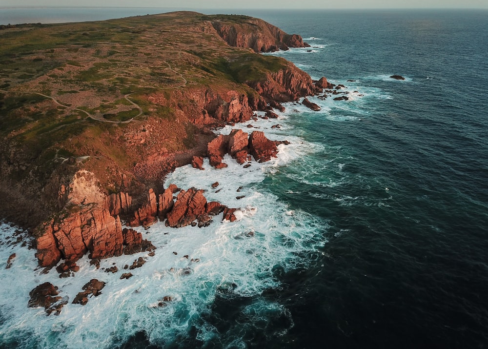 a large body of water next to a rocky shore