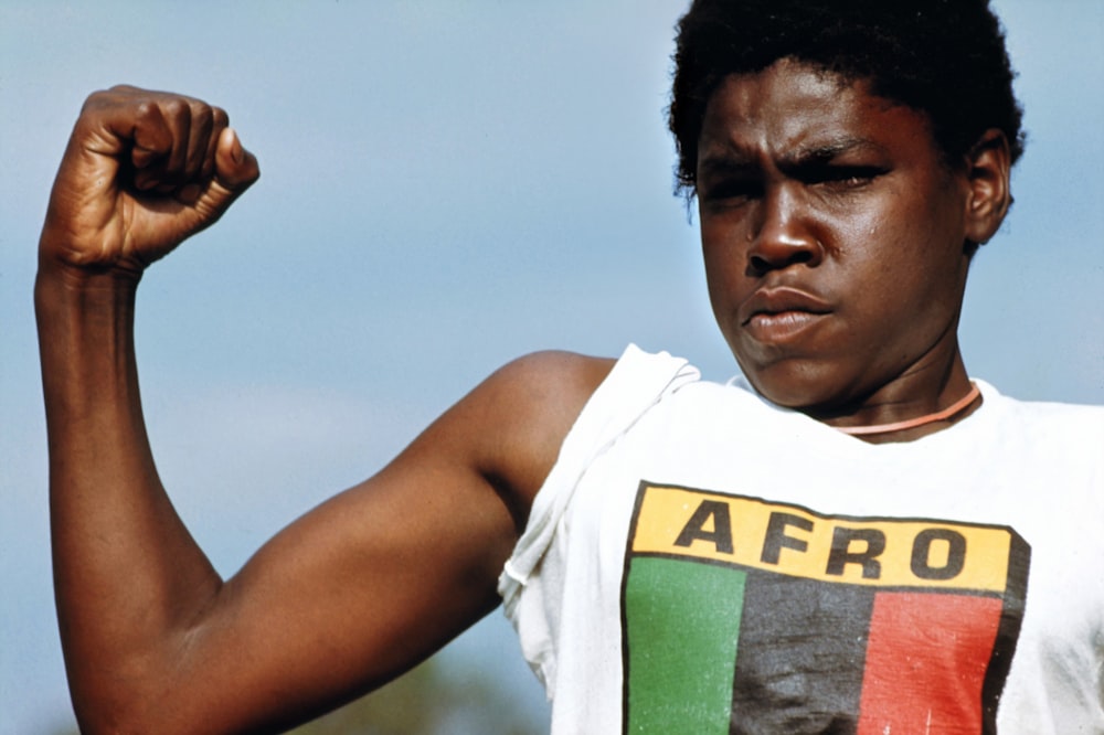 a young man flexing his muscles in a t - shirt