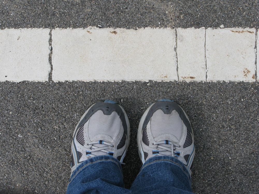 a person standing on a sidewalk with their shoes on