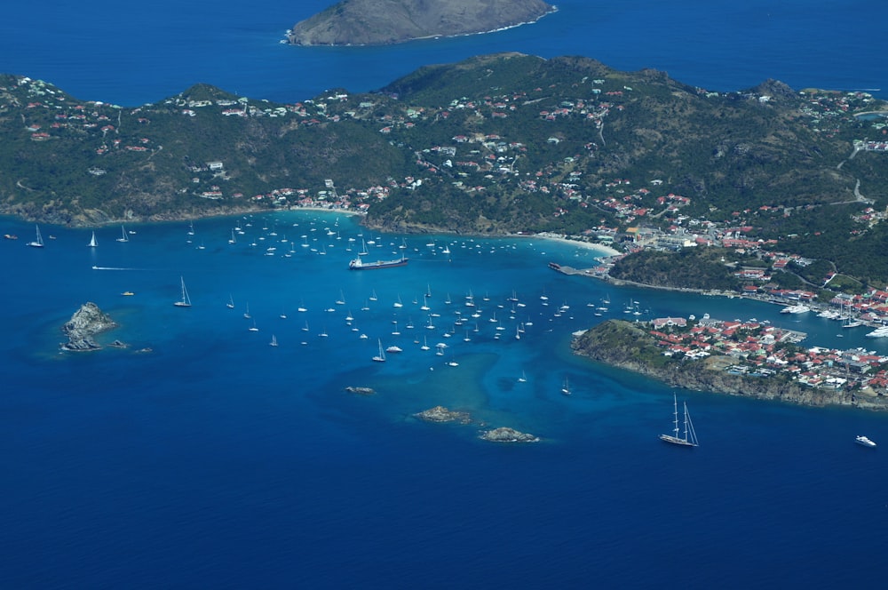 an aerial view of a small island with boats in the water