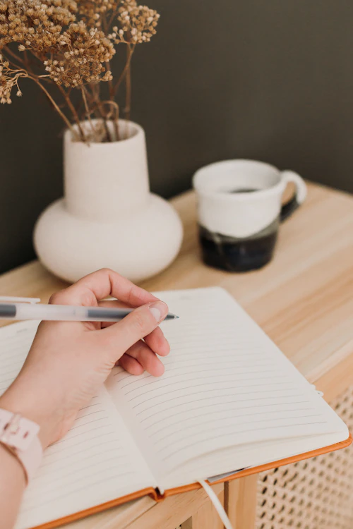 Writing on notepad with tea