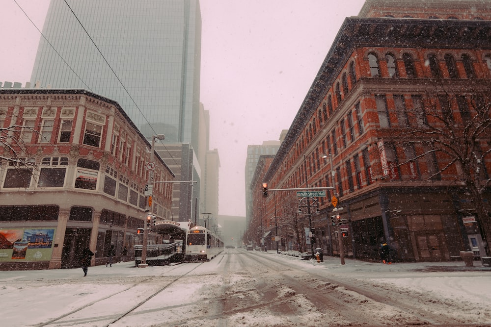 a snowy city street with a few buildings