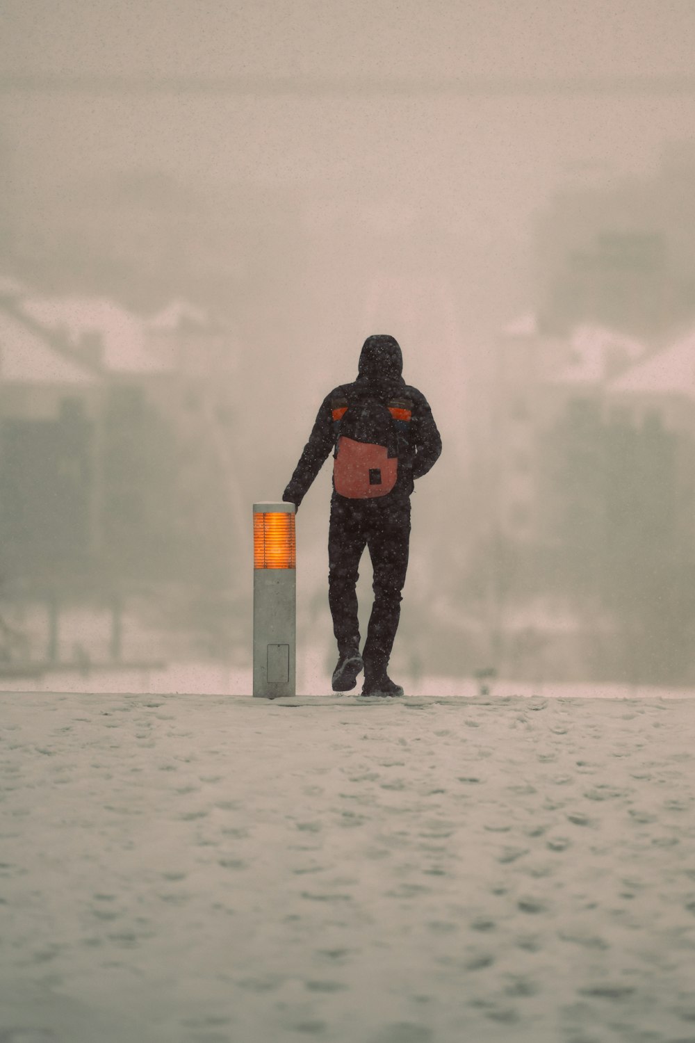 a man standing next to a fire hydrant in the snow
