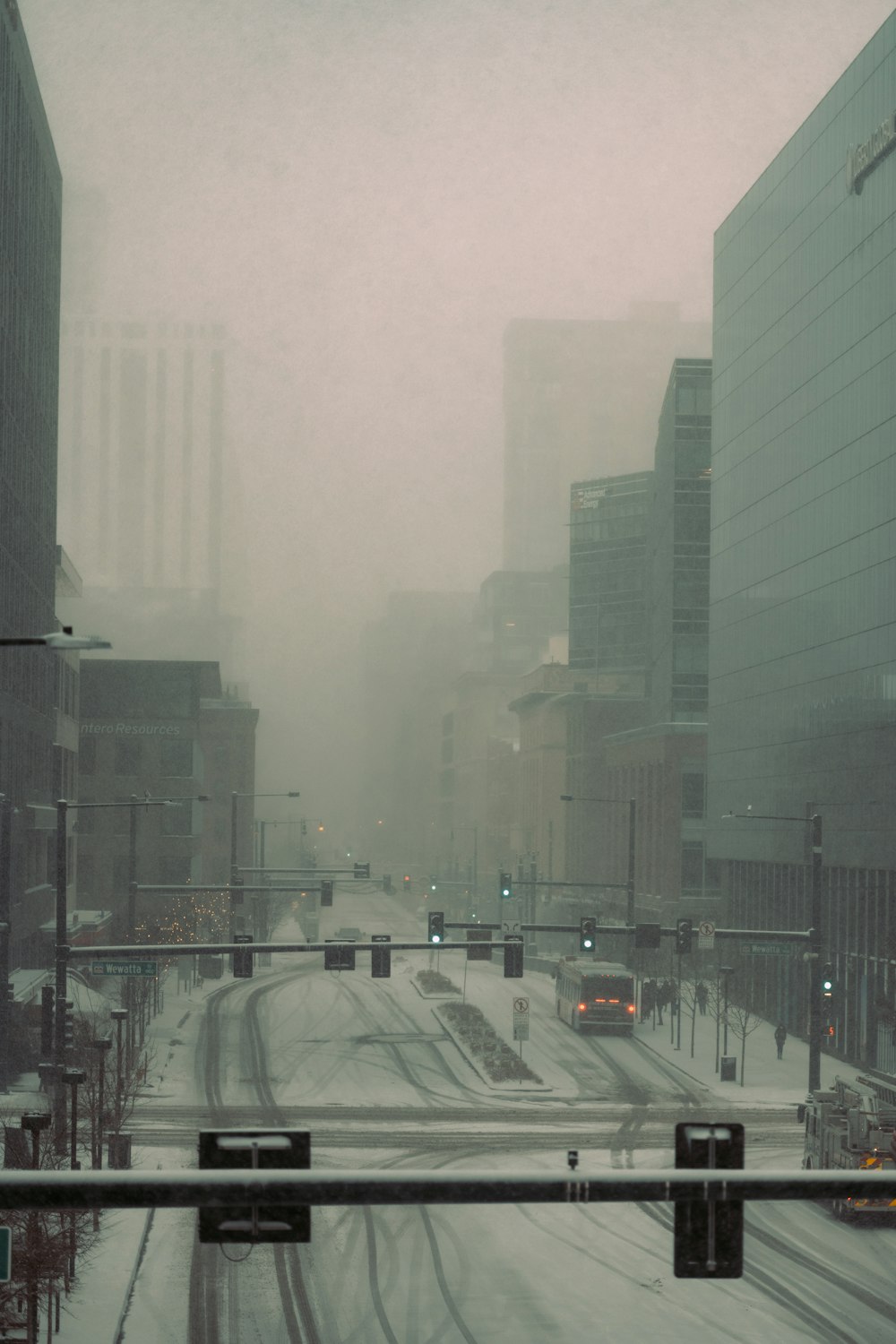 a snowy city street with traffic lights and buildings