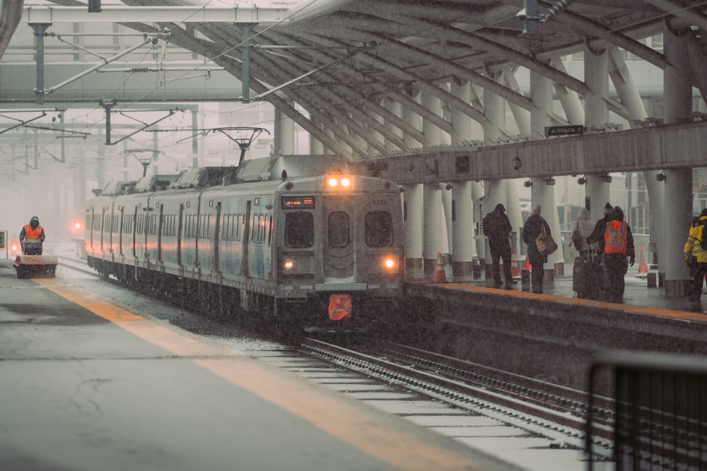 a train pulling into a train station on a snowy day