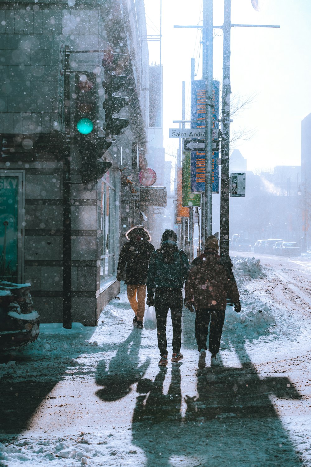 a group of people walking down a snow covered street