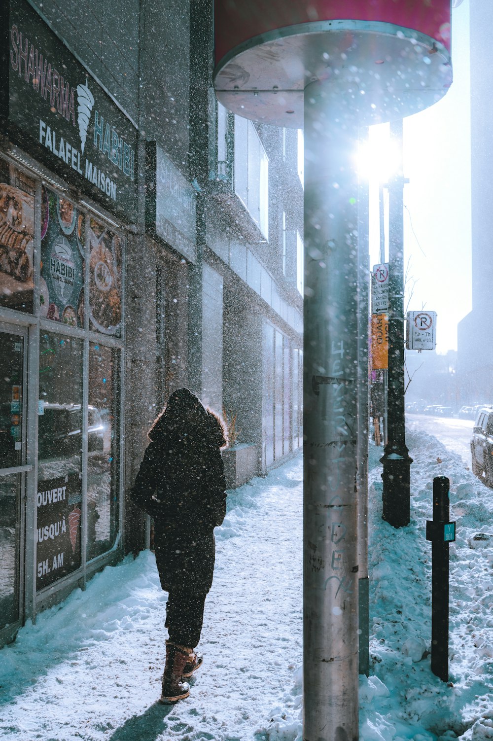 a person walking down a snow covered sidewalk