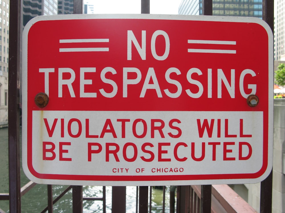a no trespassing sign posted on a gate