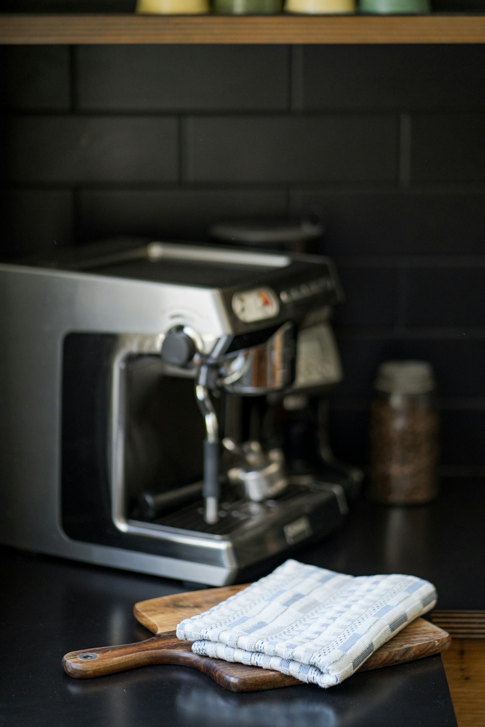 a coffee maker sitting on top of a counter next to a wooden spatula