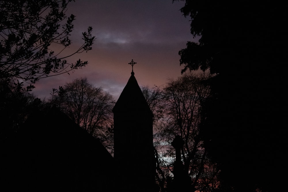 Ein Kirchturm zeichnet sich vom Abendhimmel ab