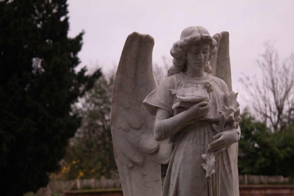 a statue of an angel holding a bowl of food