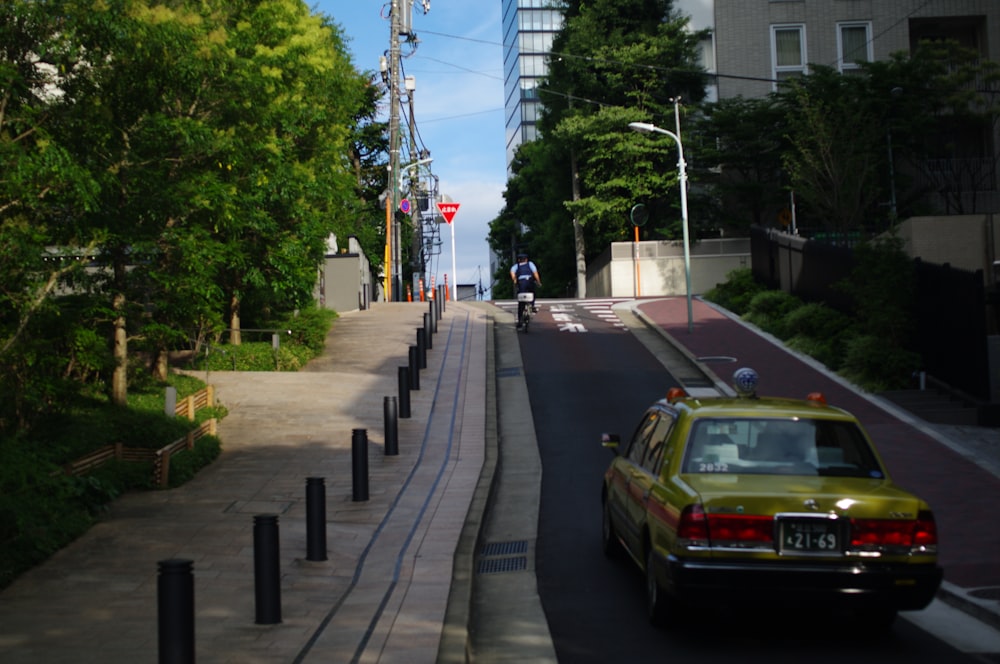 高層ビルの隣の通りを走る黄色い車