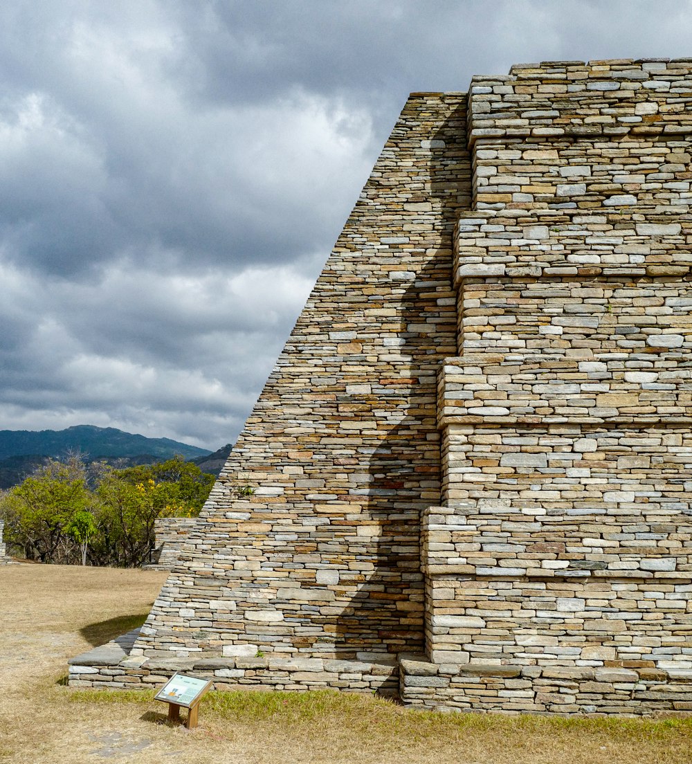 a stone structure with a bench in front of it