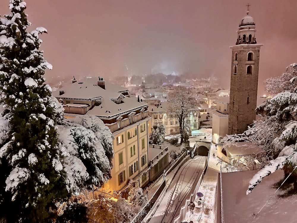 a snowy view of a city with a clock tower