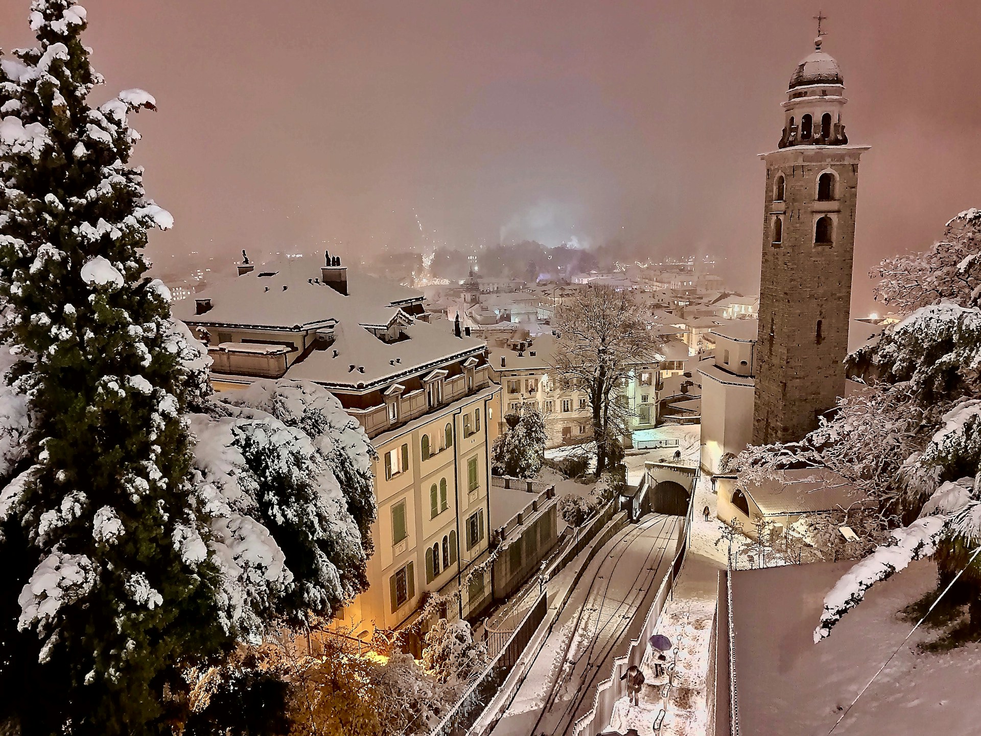 a snowy view of a city with a clock tower