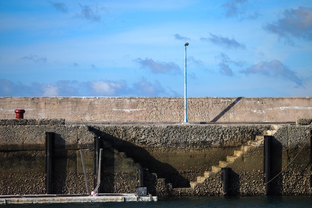 a concrete wall next to a body of water