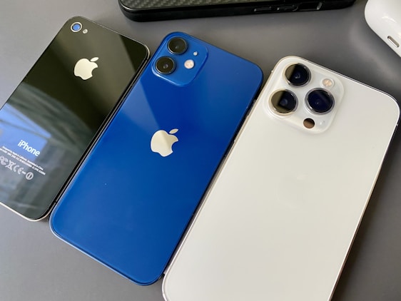 three different colored iphones sitting next to each other