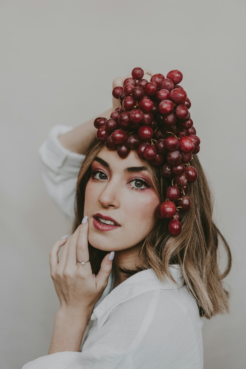 a woman with a bunch of grapes on her head