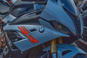 A close-up view of a motorcycle's front fairing featuring sleek bodywork, the BMW logo, and prominent graphics. The design appears aerodynamic with a combination of metallic and glossy finishes.