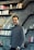 a man standing in front of a bookshelf