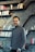 a man standing in front of a bookshelf