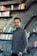 a man standing in front of a bookshelf