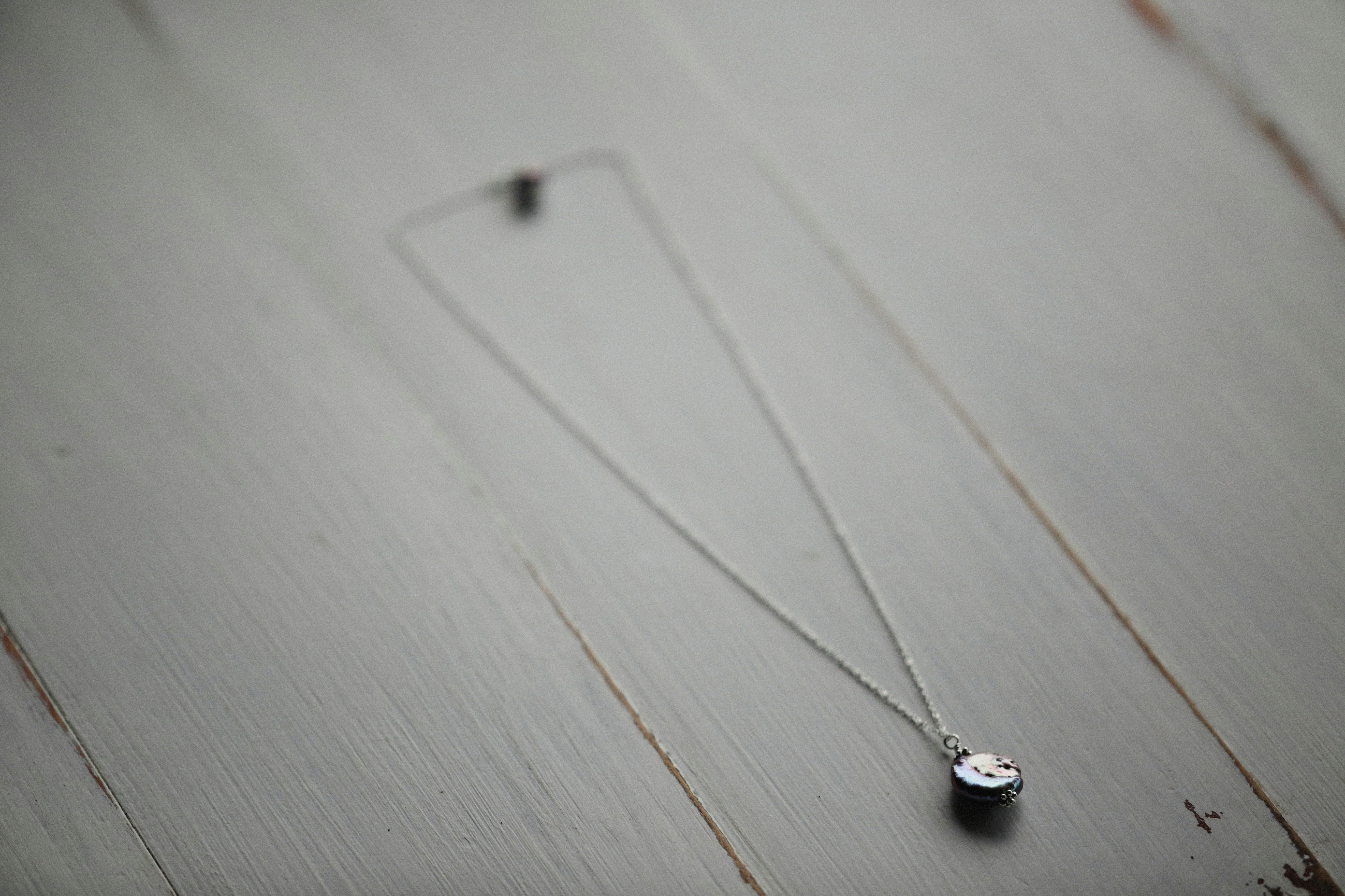 a couple of necklaces sitting on top of a wooden table