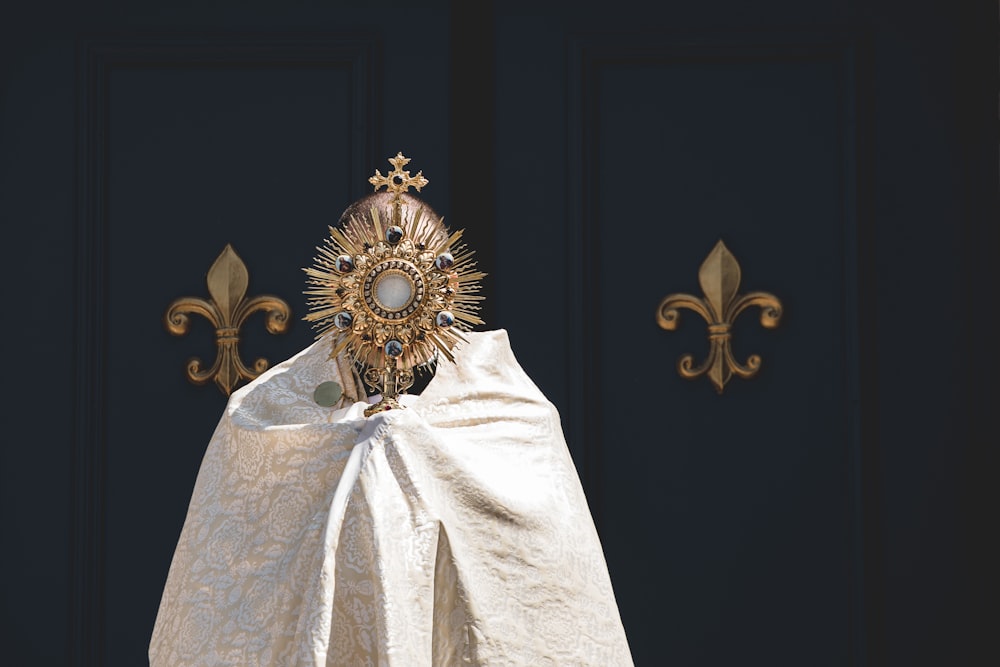 a golden crown on top of a white cloth