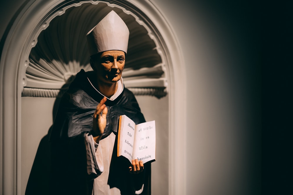 a statue of a nun holding a book