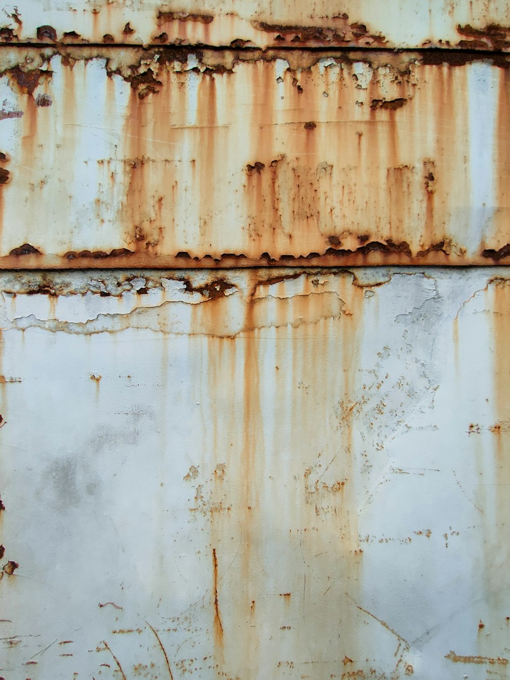 an old rusted metal surface with white and brown paint